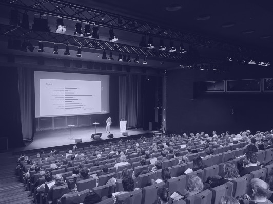 Conférence d'Anastasia Stasenko présentant une diapositive qui analyse le jeu de données compar:IA Conférence d'Anastasia Stasenko dans un amphithéâtre de la BNF, présentant une diapositive qui analyse le jeu de données compar:IA